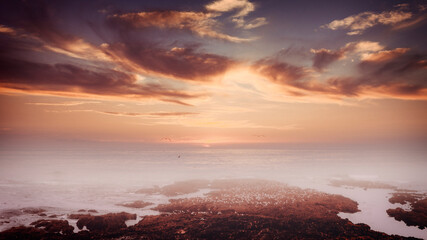 Atardecer en la playa cubierta de neblina