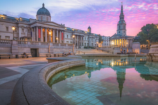 A vibrant colourful, dramatic sunrise or sunset sky at Trafalgar Square and the National Gallery in central London, UK.