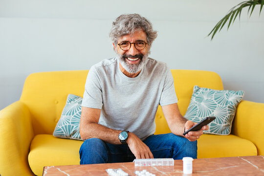 Happy senior man checking medicine by phone call
