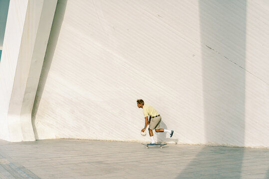 Ethnic skater riding skateboard on border