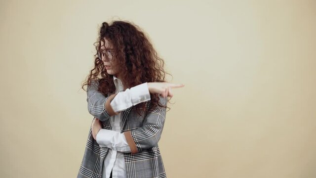 The angry, uneasy young woman, with her hands in the middle, looks insistently on the left side, looking in the opposite direction Cretaceous in gray jacket and white shirt, with glasses posing