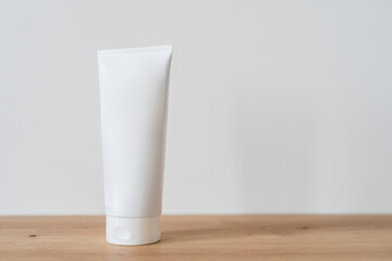 White tube cream mockup on a wooden table.