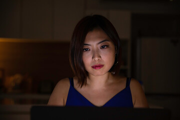 Woman working from home at night - looking at illuminated screen