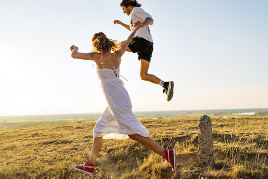 Cheerful young couple having fun in summer field