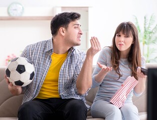 Family pair watching football at home
