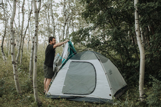 Man Setting up Tent at Campsite