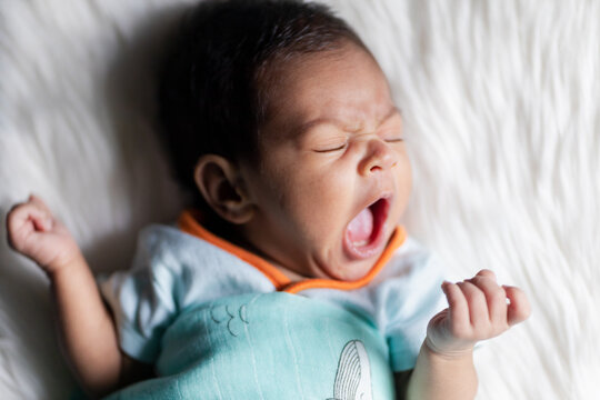 Cute newborn baby stifles a yawn