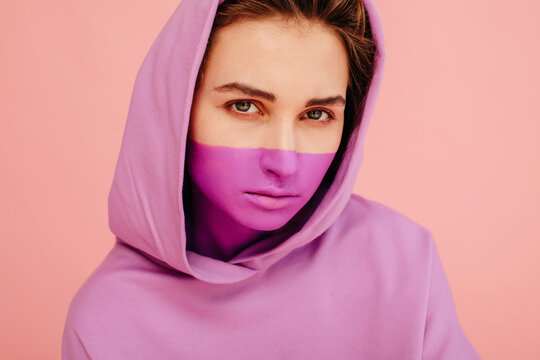Serious model in painted face mask and hood