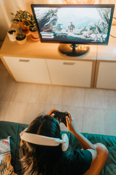 Unrecognizable woman gaming at home