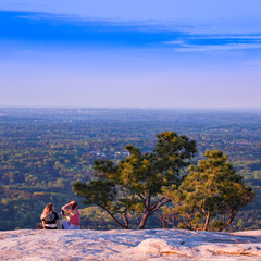 Friends Hanging Out On Top Of Mountain After A Hike