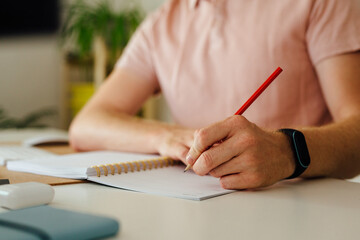 Anonymous Man Taking Notes In A Notebook