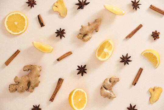 Ginger, lemon, cinnamon sticks and star anise on beige background