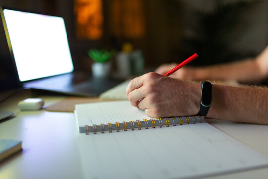 Anonymous Man Taking Notes In A Notebook
