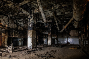 Fototapeta na wymiar Burnt and ruined interior of industrial building after fire. Consequences of war, fire or other disaster