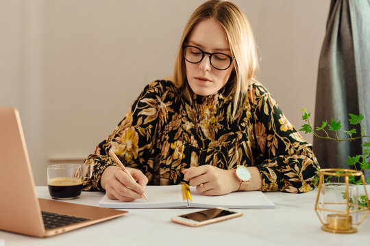 Young Woman Taking Notes At Home