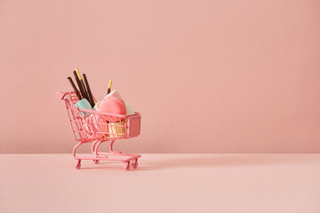 shopping cart loaded with marshmallows, chocolate biscuit stick and macaron