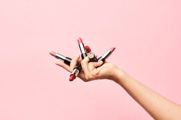 Crop person showing lipsticks for makeup