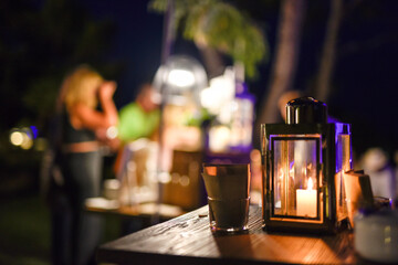 Candle lamp in a party setting at night and people