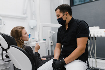 Diverse dentist and patient talking during appointment