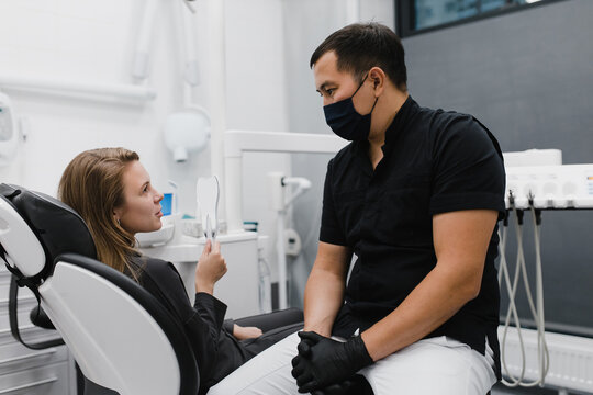 Diverse dentist and patient talking during appointment