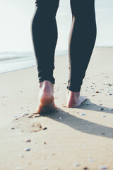 Joven mujer paseando por la orilla del Mediterráneo mojando sus pies en el mar. 