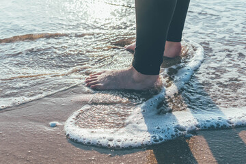 Joven mujer paseando por la orilla del Mediterráneo mojando sus pies en el mar. 