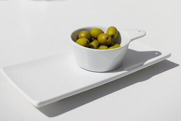 Short Shot of a bowl of green olives on white background. Benefits of the mediterranean diet.