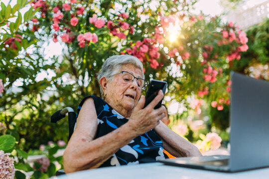 Happy elderly woman on videocall using a modern laptop