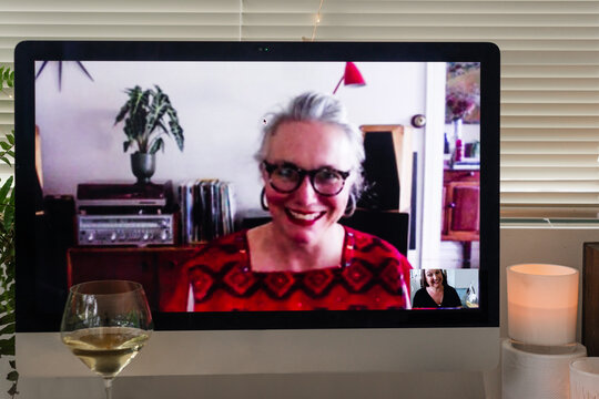 two friends sharing a wine over video
