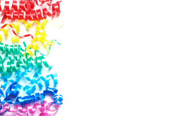 Colorful serpentine streamers on white background, top view