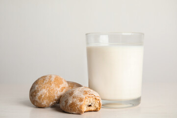 Tasty homemade gingerbread cookies and glass of milk on white table
