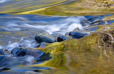 USA, Oregon. Abstract of autumn colors reflected in Wilson River rapids.