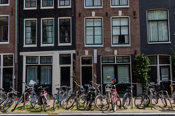Fototapeta na wymiar Row of bicycles parked on the sidewalk outside suburban buildings