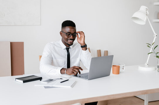 Ethnic manager using laptop at desk