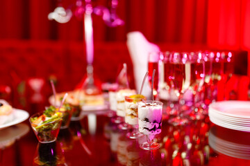 buffet table with toasts and snacks and desserts in red tones