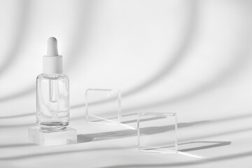 Serum cosmetic bottle mockup on acrylic transparent solid block pedestal on white background,...