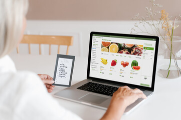 Woman making online order of fruits on laptop
