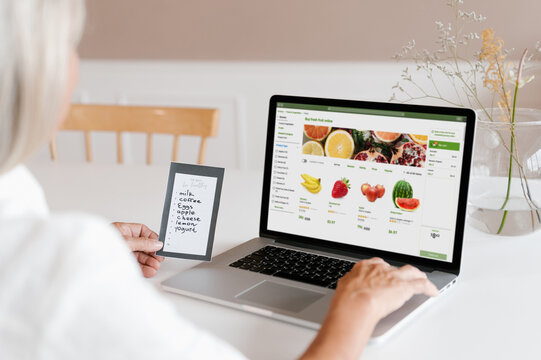 Woman making online order of fruits on laptop