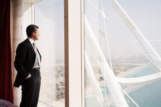 Businessman Looking out Hotel Window