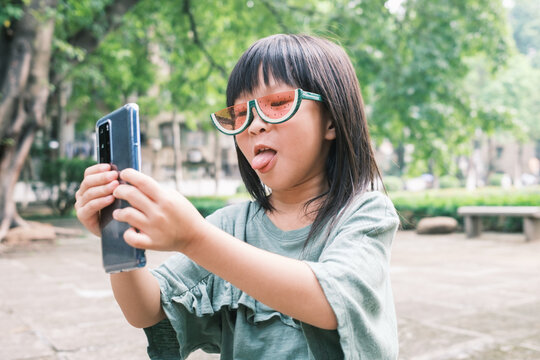 young child playing mobile phone outdoors