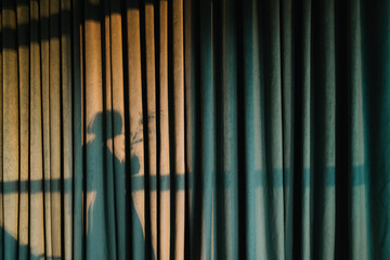 shadow of a woman on green velvet curtain