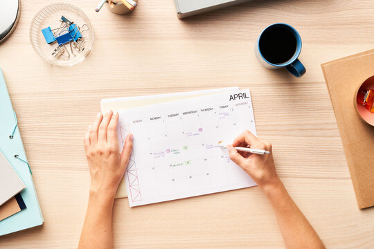 Unrecognizable person making notes in calendar