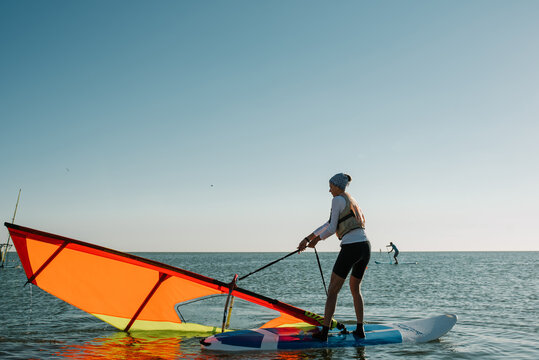 A girl learn to sail on a windsurf on the summer day