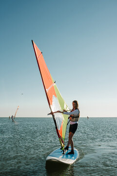 A girl sails on a windsurf on the sea