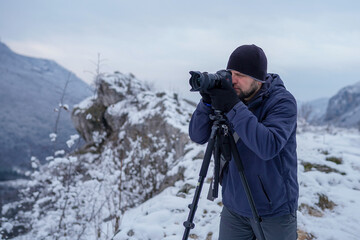 Photographer capturing a beautiful view on mountain with camera