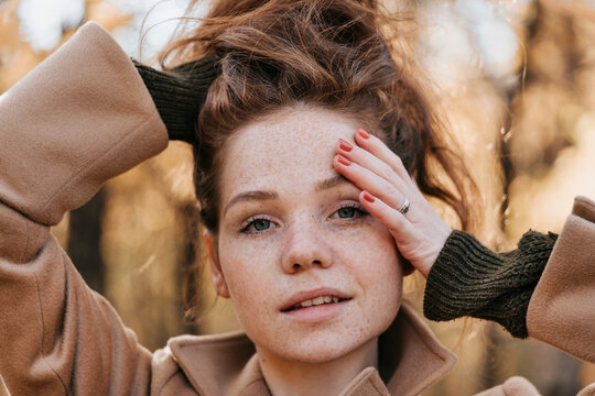 Portrait of a red-haired young girl in autumn outdoors.