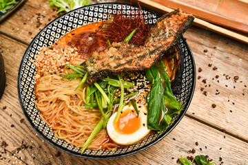 Miso Ramen Asian noodles with egg, pork and pak choi cabbage in bowl on white background. Japanese...