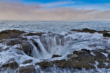 Thor's Well with surf cascading into the well along the Oregon coastline