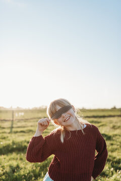 Girl covering eyes with feather