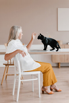 Cheerful mature woman stroking cat